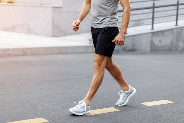 HOMBRE-CON-ROPA-Y-CALZADO-DEPORTIVOS-CAMINANDO-EN-LA-CALLE-EJERCICIO-Y-HEMORROIDES-CAMINATA-CAMINAR