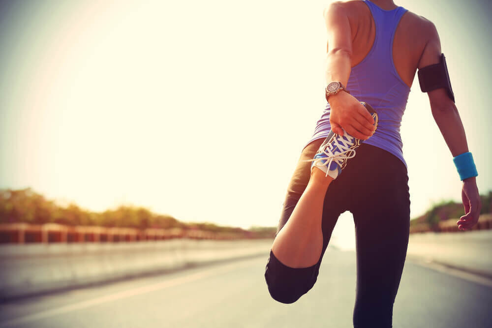 MUJER EN ROPA DEPORTIVA HACIENDO ESTIRAMIENTOS EJERCICIO Y HEMORROIDES